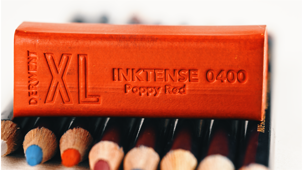 Derwent Ikntense red XL block sits on top of a line of colorful pencils.