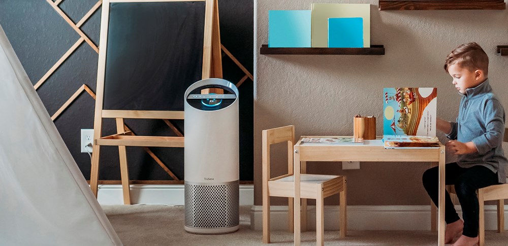 little boy playing in his room with trusens air purifier in the corner