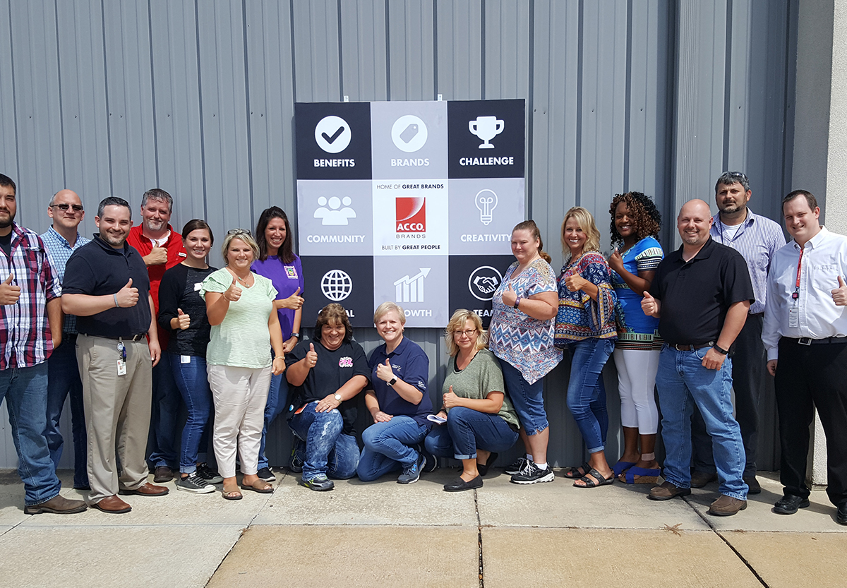 Employment Brand banner behind a group of employees smiling together