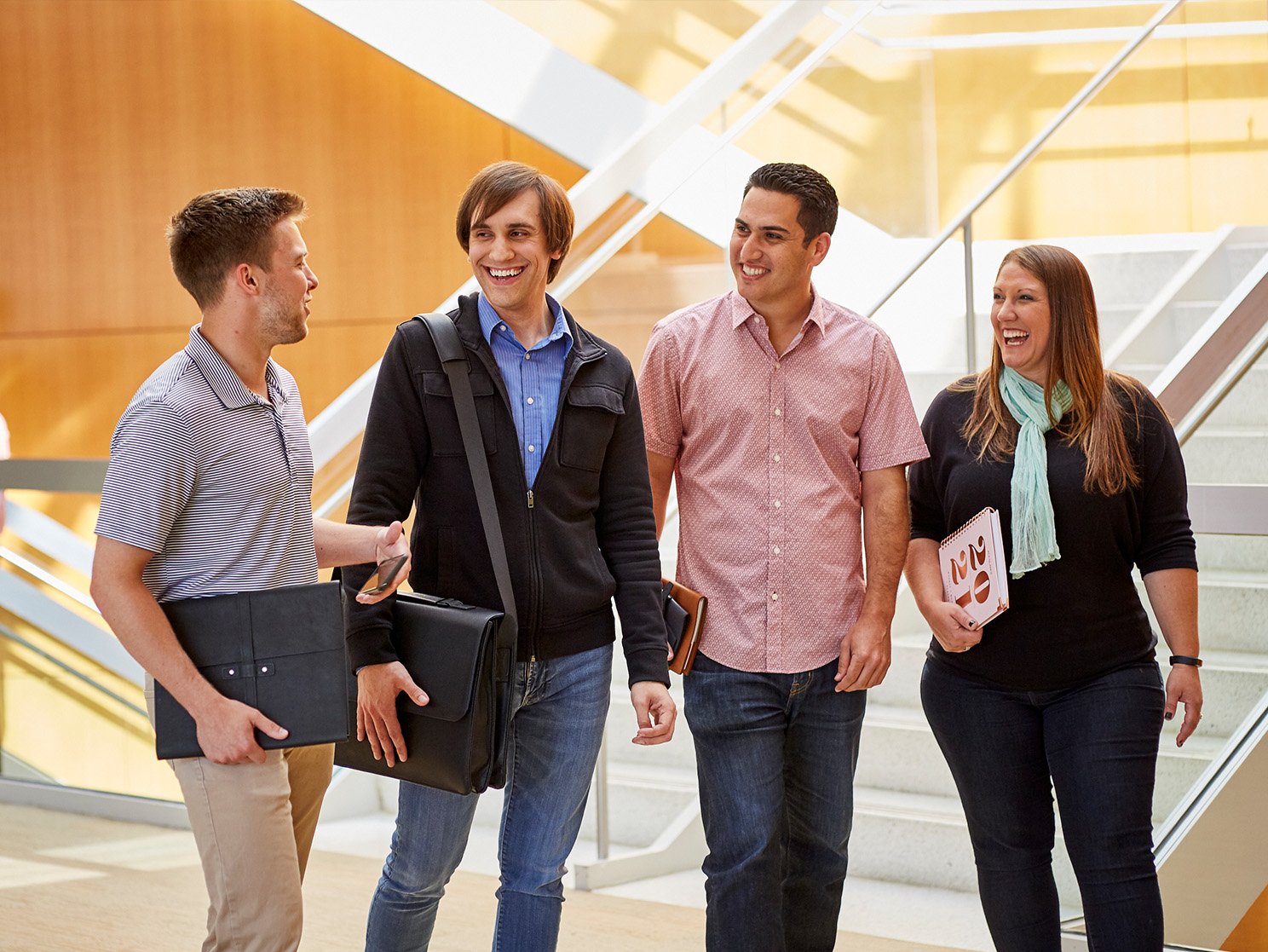 Four ACCO Brands employees walking by staircase and talking